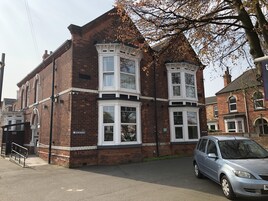 A two-story building with a brick facade and white-framed windows.