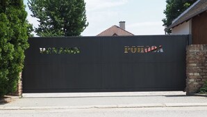 Una entrada con puerta, con el nombre "PONTA DOA" en letras doradas sobre un fondo negro.