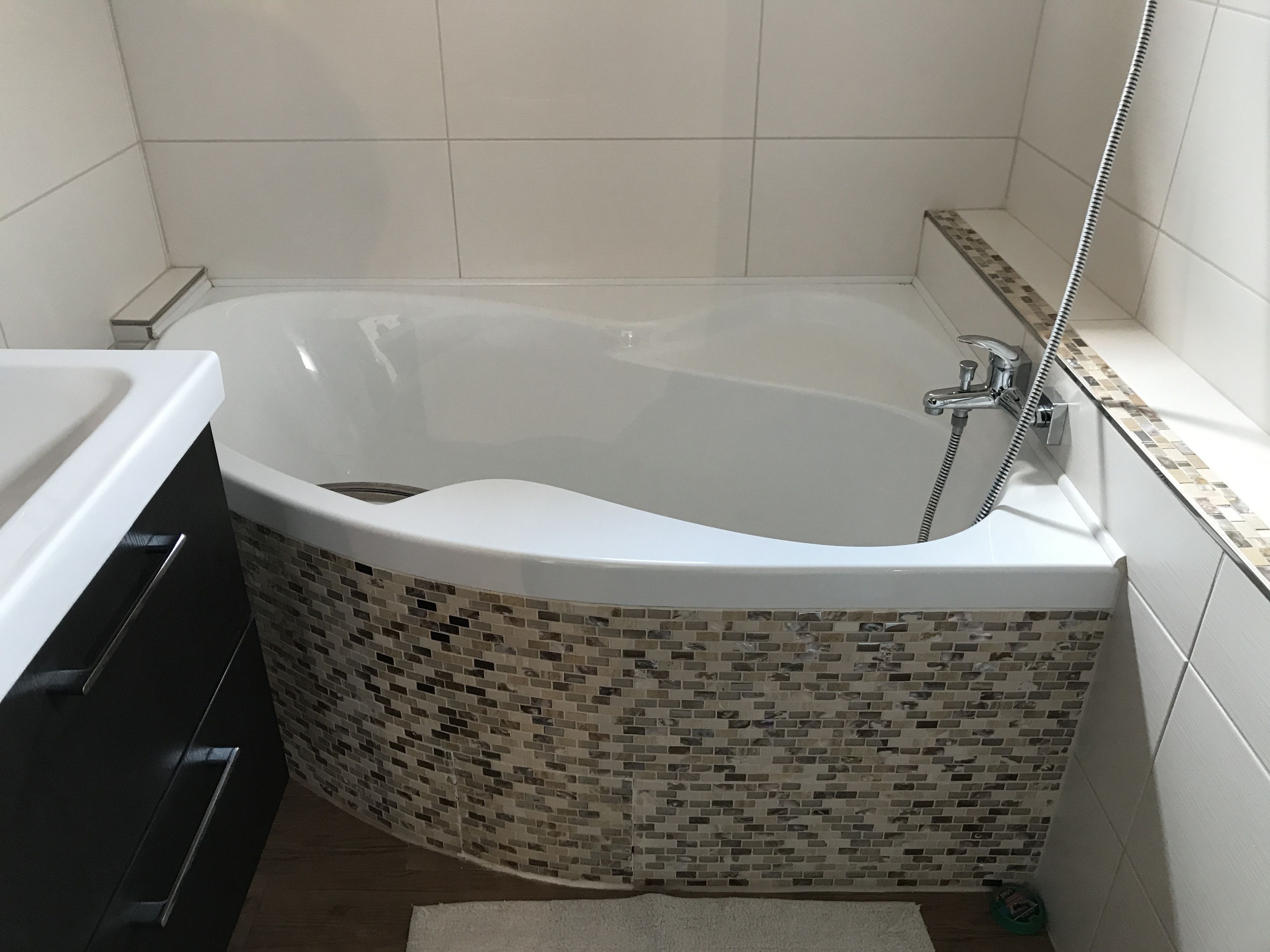 A modern bathroom with a freestanding bathtub, a shower, and a tiled floor.