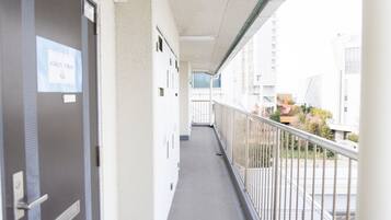 A corridor with a door labeled "Kids Room 6A" leading to a balcony with a metal railing.