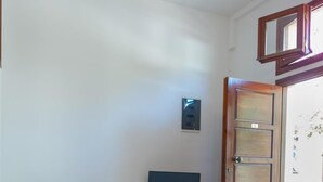 A living room with a sofa, a small table, and a television. - Pallazzo Fortezza (Rethymno)
