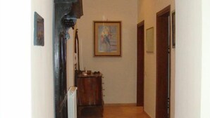 Un pasillo con un radiador, un armario de madera y un cuadro en la pared.