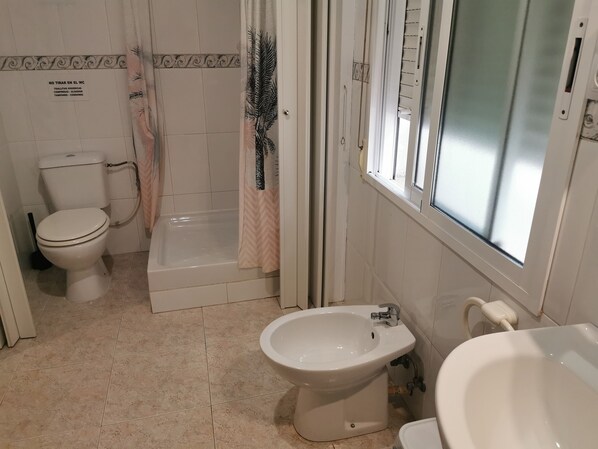 A bathroom with a toilet, bidet, and bathtub. - Hostal Castellverd (Vinaros)