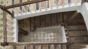 A staircase with a white railing and a patterned tile wall. - La Madriguera de Tomaso (Valle de Yerri)