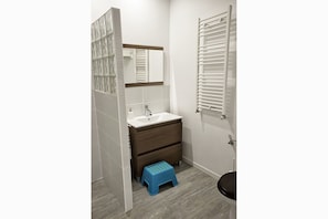 A bathroom with a white sink, a mirror, a towel rack, and a blue step stool. - La Madriguera de Tomaso (Valle de Yerri)