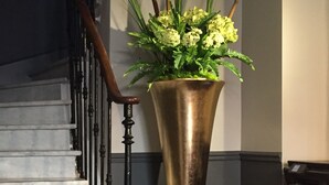 A staircase with a brass vase of flowers.