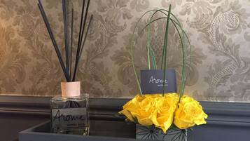 A bottle of Arome Hotel Nice fragrance and a bouquet of yellow roses.