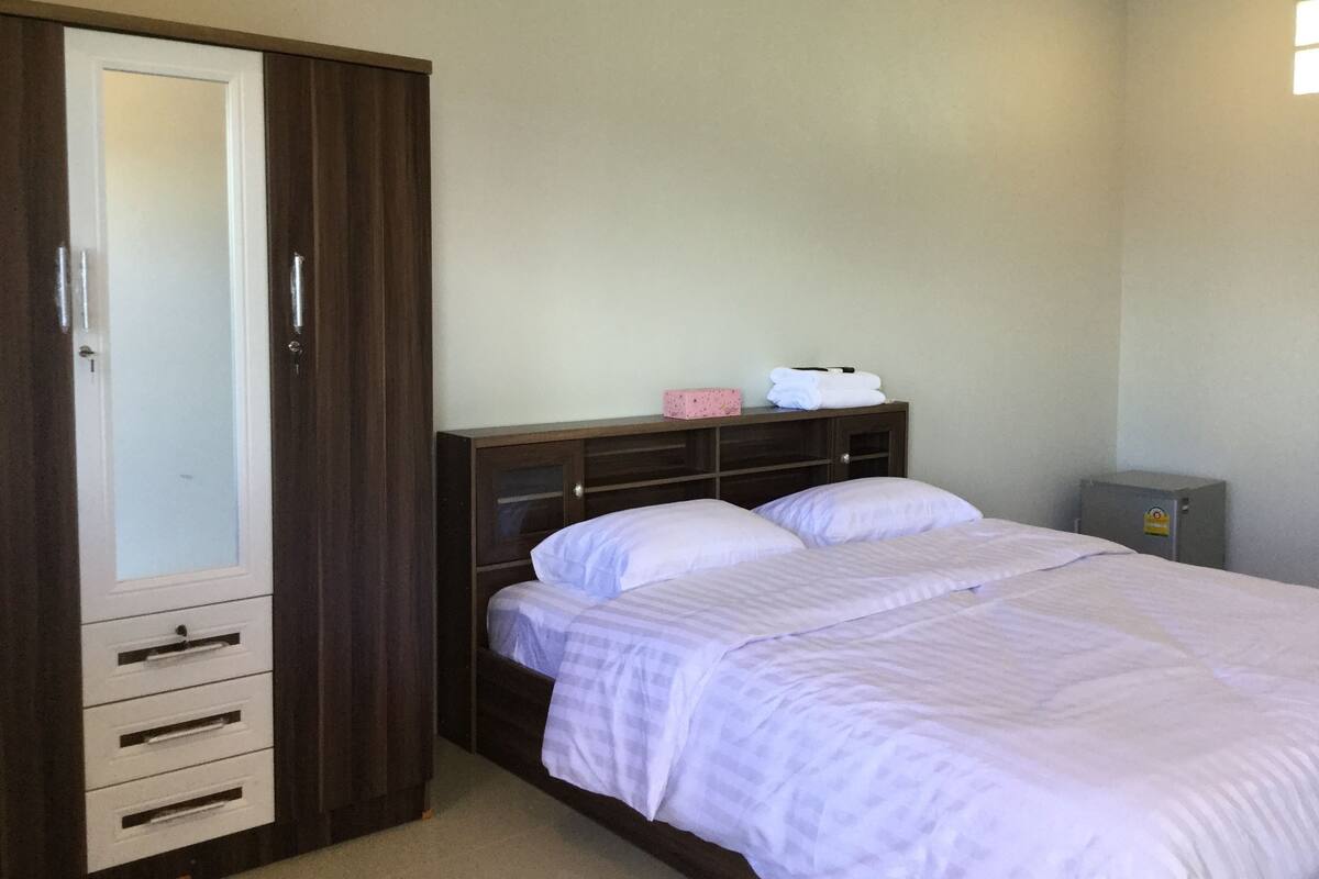 Un dormitorio con cama, armario y una pequeña alacena.