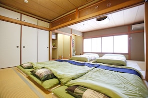 A traditional Japanese-style bedroom with tatami flooring, a futon bed, and sliding doors.