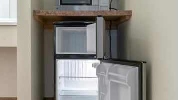 Una cocina compacta con microondas integrado y refrigerador.