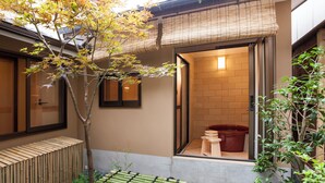 A traditional Japanese-style room with tatami flooring, a shoji screen door, and a view of a hot spring bath. - Private Residence Nijo-jo Nagomi (Kyoto)