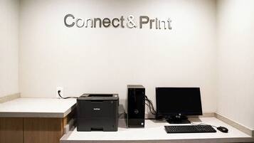 A desk with a Brother printer, an HP monitor, and a keyboard.