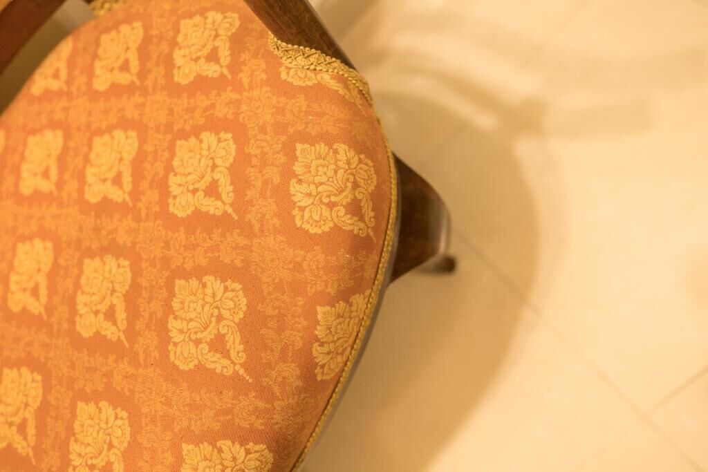 A close-up of a chair with a patterned fabric.