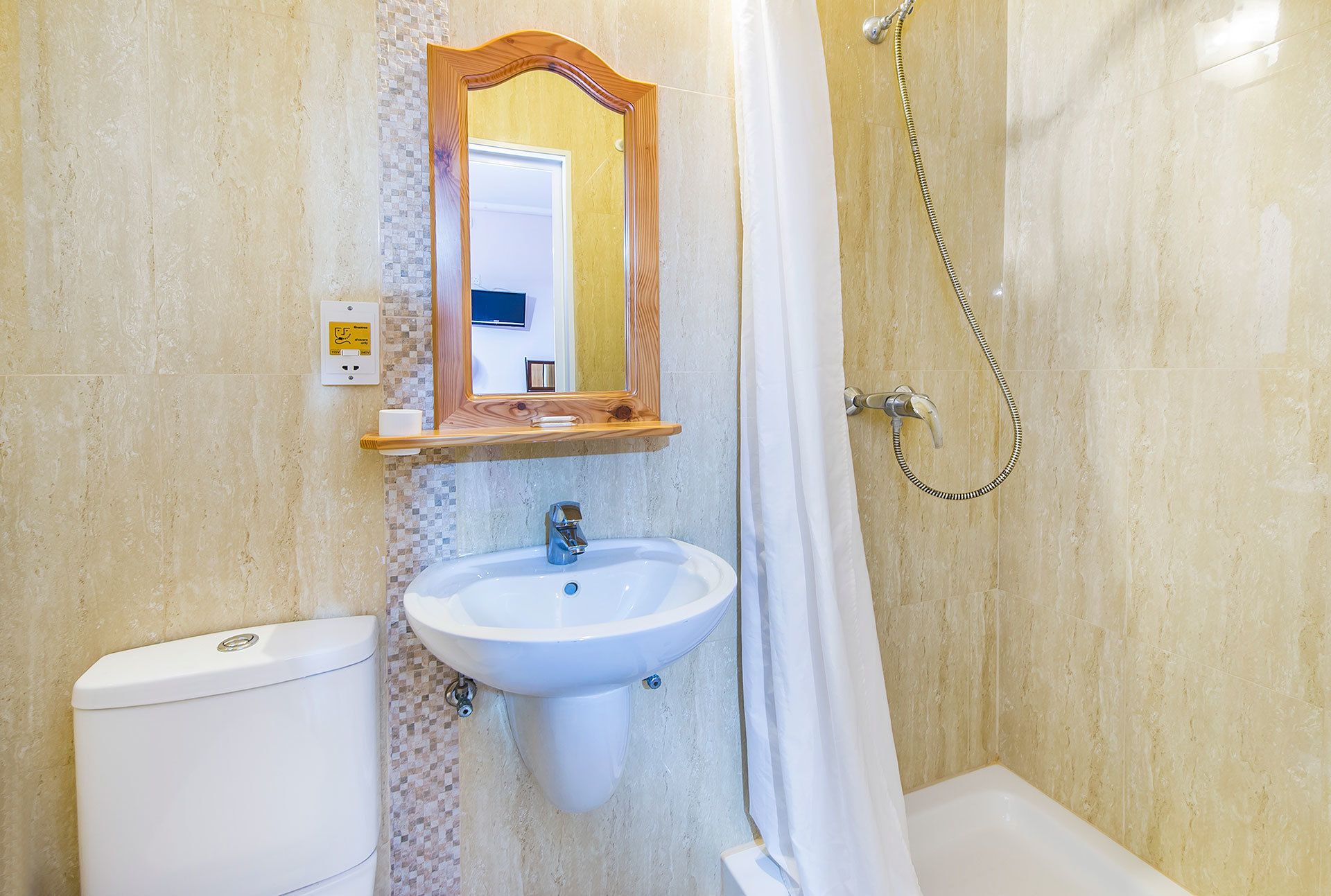 A bathroom with a toilet, sink, and shower.