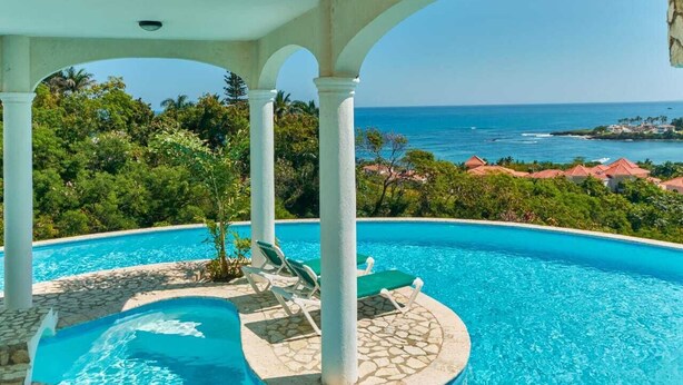 A pool with a view of the ocean and a tropical landscape. - Private Ocean View Villa - Chef & Staff Included (Puerto Plata)