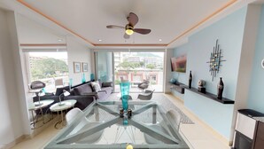 A modern living room with a glass dining table, sofas, and a ceiling fan. - Beautiful condo one block to the beach! 1BD Condo for rent in Old Town, Puerto v (Puerto Vallarta)