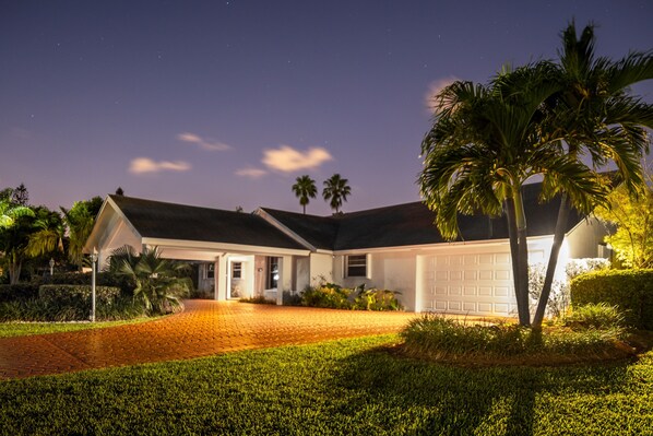 A house with a garage, a driveway, and a well-maintained lawn.
