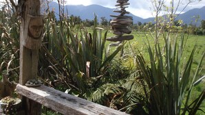 Una estructura de fusta rústica amb una paret de pedra i una composició penjant de pedra.