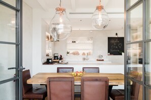 A modern dining area with a wooden table, leather chairs, and a glass partition. - Renovated gorgeous villa in Florence. Walking distance to all sites. (Firenze)