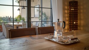 Ett träbord med en kaffebryggare, koppar och ett bricka.