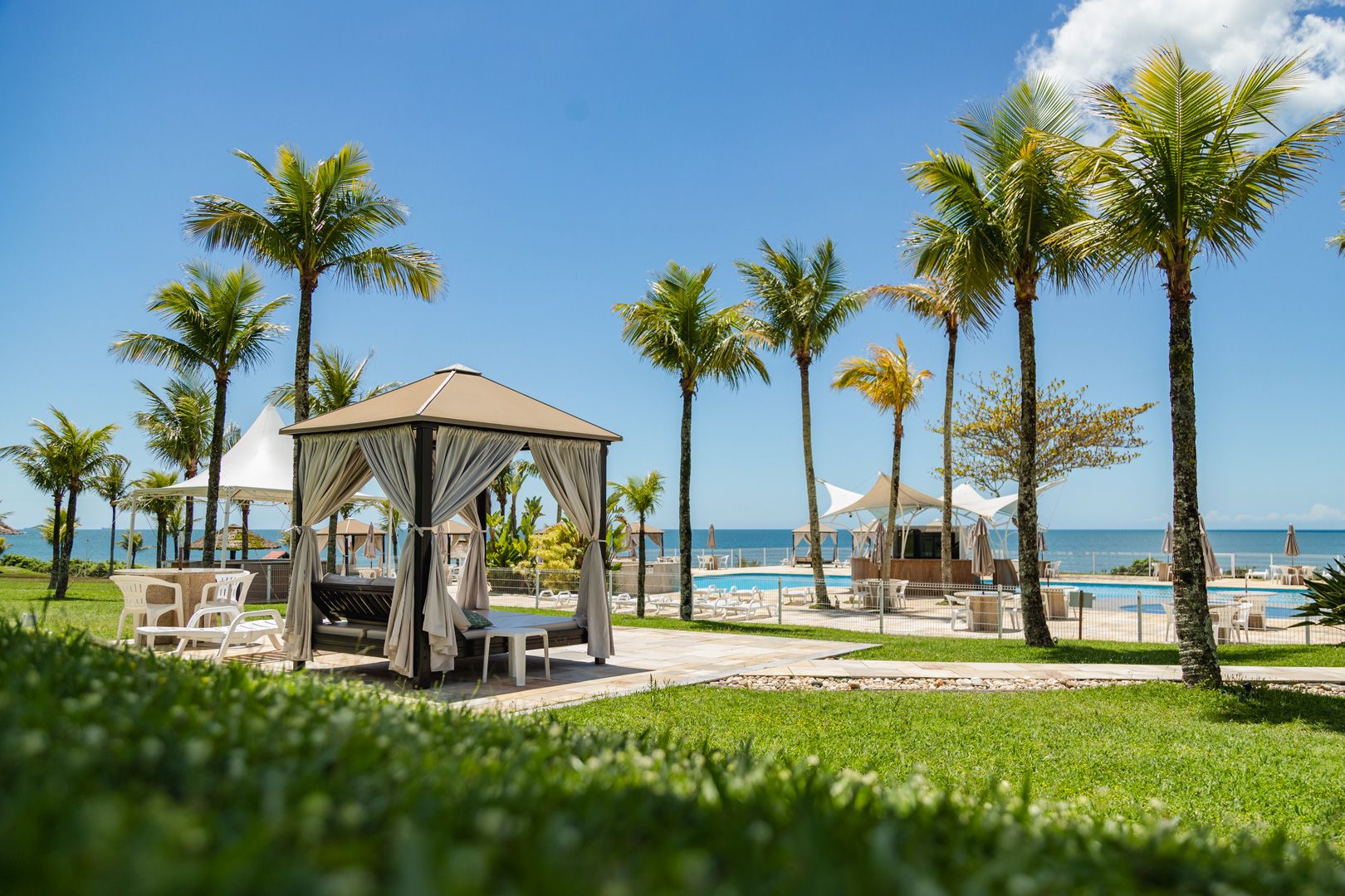 Un complexe hôtelier situé en bord de mer, doté d’un belvédère, de chaises longues et d’un espace piscine.