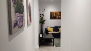 A modern living room with a dark blue sofa, yellow and striped pillows, a black coffee table, and a painting on the wall. - MODERN APT WITH IDEAL LOCATION NEXT TO ATOCHA STATION (Madrid)