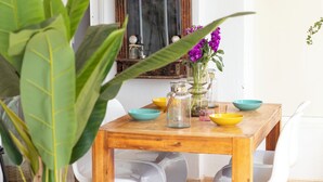 A wooden dining table with bowls, a vase with flowers, and a mirror. - Family-friendly apartment 20 m from Arenal Beach, Calpe (CALPE)
