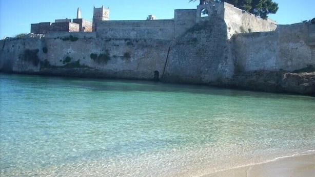 Una fortificación costera con aguas cristalinas al frente.