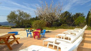 Outdoor seating with tables and chairs, a picnic table, and a tree with blossoms.
