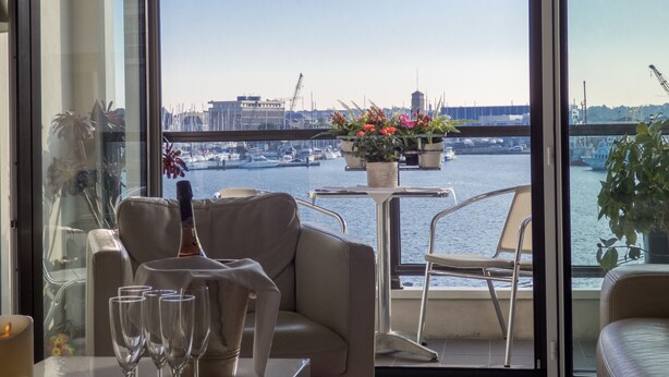 A dining area with a view of a marina and boats. - Luxury 4* apartment with closed garage and pond view 50m from the Sillon beach (Saint-Malo)