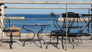 A terrace with metal chairs and tables overlooking a coastal view. - HOUSE 4 * SEA VIEW TERRACE SEASIDE NORMANDY CALVADOS BEACH OMAHA BEACH  (Port-en-Bessin-Huppain)