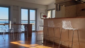 A modern interior with a bar area featuring clear chairs and a wooden counter. - HOUSE 4 * SEA VIEW TERRACE SEASIDE NORMANDY CALVADOS BEACH OMAHA BEACH  (Port-en-Bessin-Huppain)