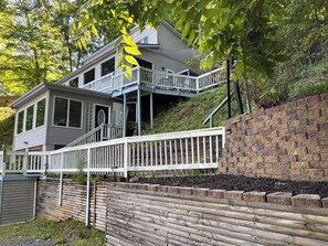 A two-story house with a balcony, a wooden fence, and a brick wall.