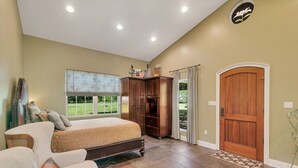 A bedroom with a large bed, a wardrobe, a desk, and a window with a view of the outdoors. - Farm Stay: Come Stay With Us (Fairhope)