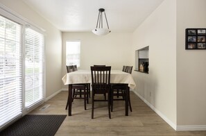 A dining area with a table set for four, a ceiling light, and a window with blinds. - Newly Renovated Ski Home with Spa Close to Snowbird/Alta/Solitude/Brighton (Salt Lake City)