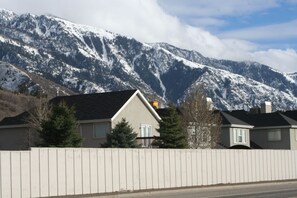 A residential area with houses, a wooden fence, and snow-covered mountains in the background. - Newly Renovated Ski Home with Spa Close to Snowbird/Alta/Solitude/Brighton (Salt Lake City)