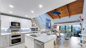 A modern kitchen with stainless steel appliances, a granite countertop, and a wooden ceiling. - Coquina Beach 3G- Gorgeous 2bd, plus loft, Sanibel beach condo! (Sanibel)