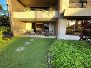 Un bâtiment moderne à deux étages, doté d’un balcon, d’un espace extérieur aménagé pour s’asseoir et d’une pelouse bien entretenue.