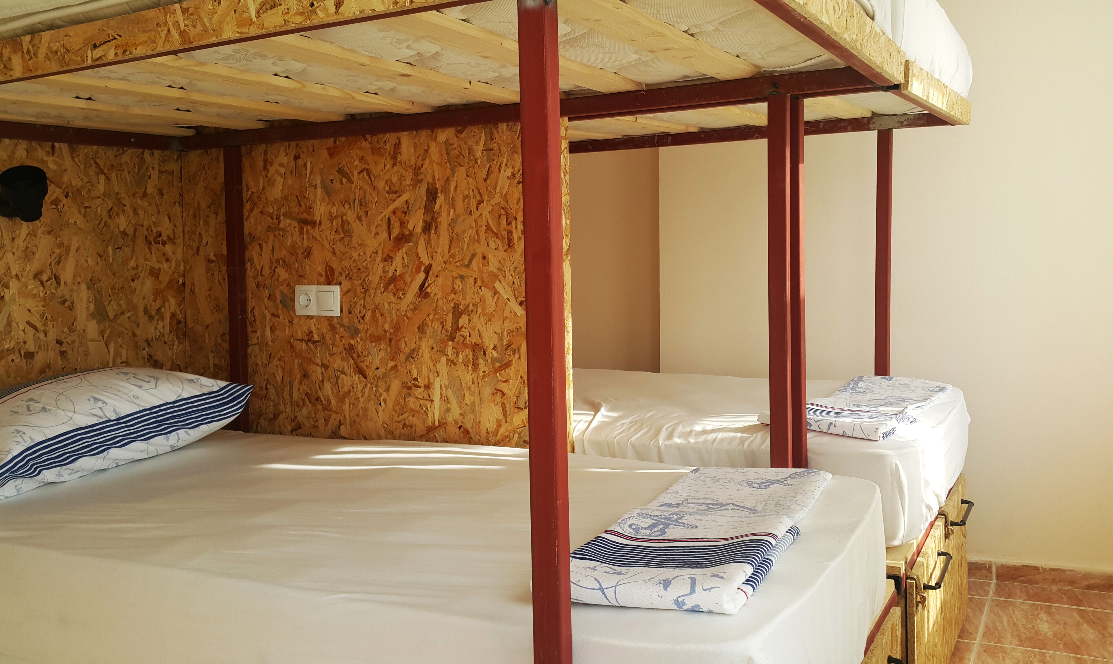 A bunk bed room with wooden walls and a simple, functional design.