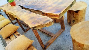 Una mesa de madera con un diseño único en el borde y taburetes de madera a juego.