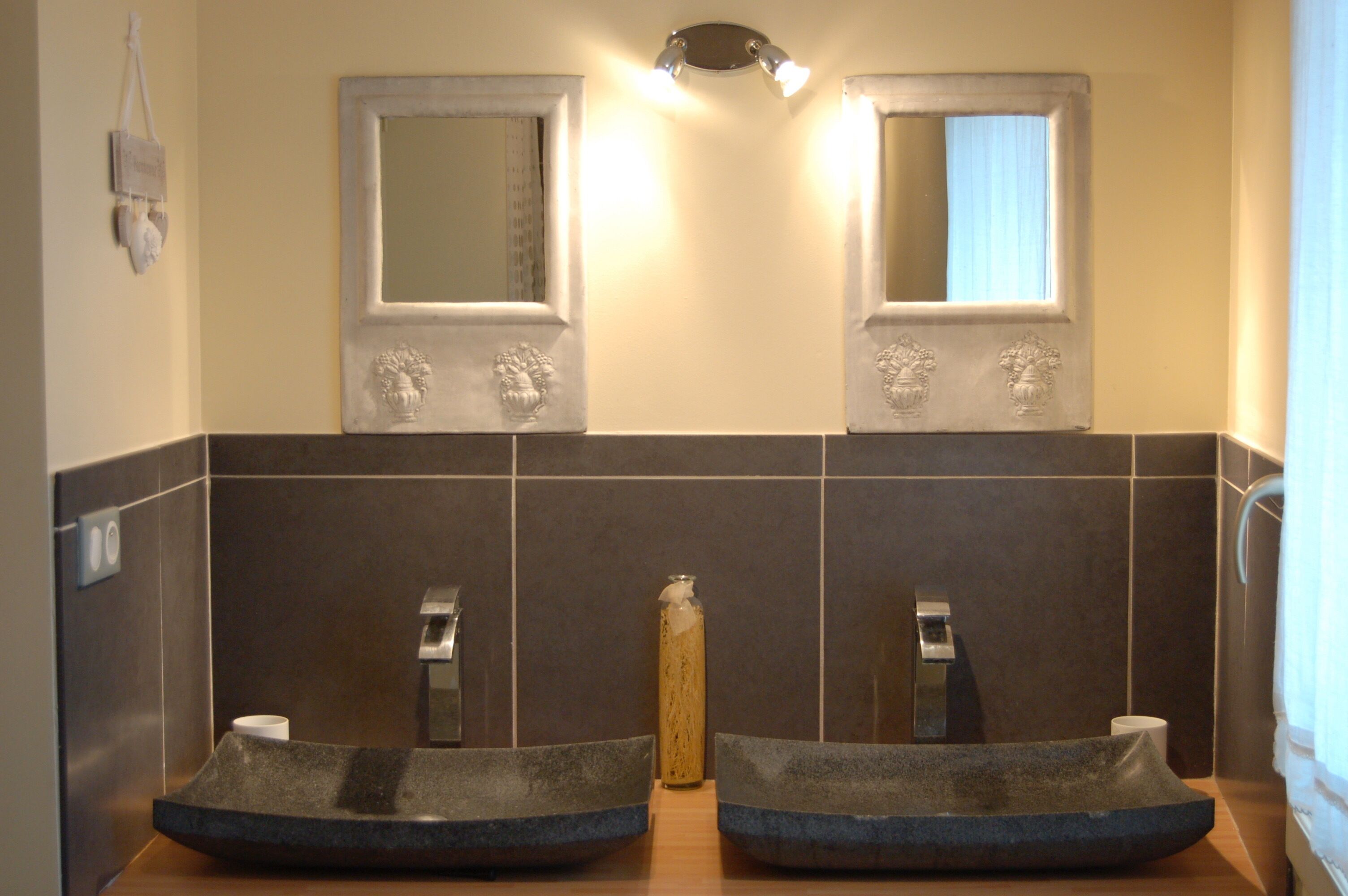 Un baño con dos lavamanos, un espejo y un perchero para toallas.