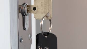 A door lock with a key and a keychain labeled "The Glazer Hotel."