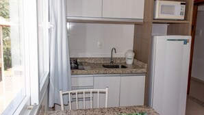 A compact kitchen with a sink, a microwave, and a refrigerator. - Pousada Villa Maciel (Bombinhas)
