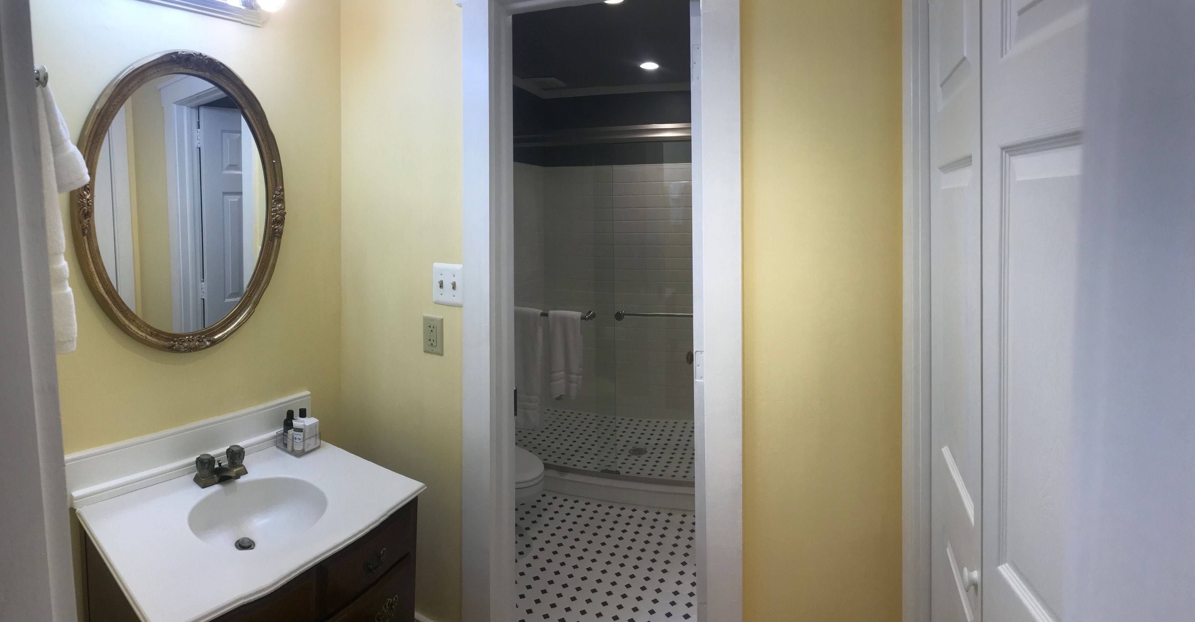 Un baño con lavabo blanco, espejo y ducha.