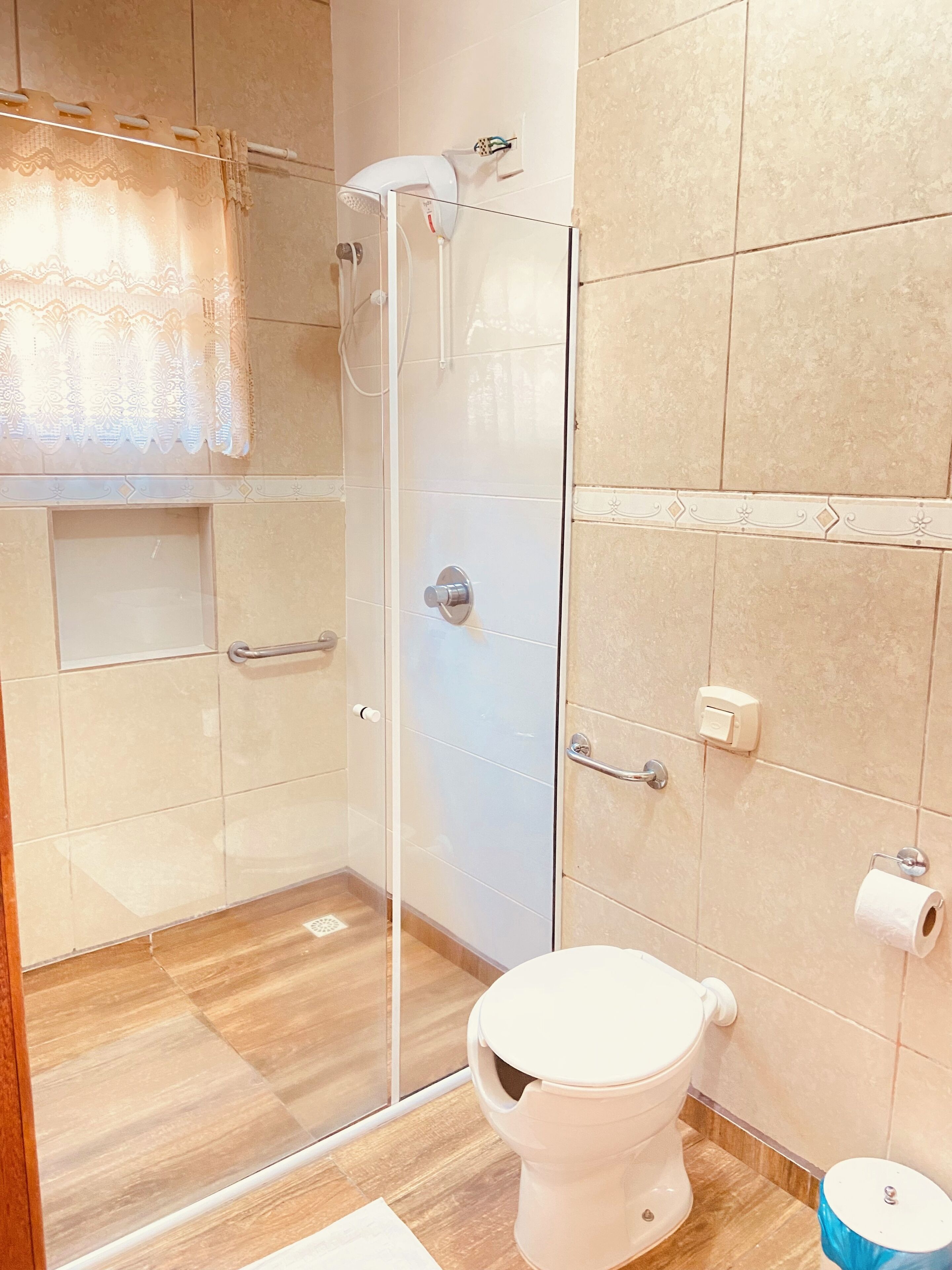 A modern bathroom with a glass shower enclosure, a toilet, and a sink.