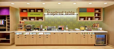 A modern kitchen with an inspired table, wooden cabinets, and a refrigerator.