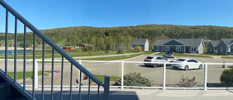 A residential area with a parking lot, houses, and a hill in the background.