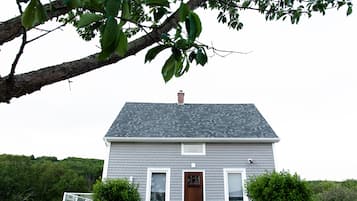 A house with a grey roof, white trim, and a brown door.