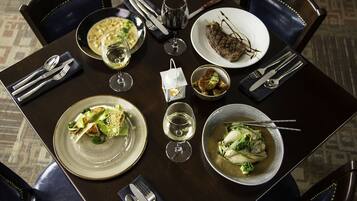A dining table set with plates, bowls, cutlery, and glasses, suggesting a meal setting.