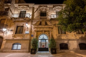 A historic building with a grand entrance, ornate balconies, and a sign indicating it is a hotel. - Hotel Rector (Salamanca)